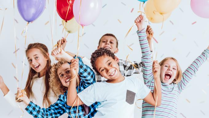 Photography of happy kids with baloons and confetti.